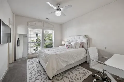 a bedroom with a large bed and a window