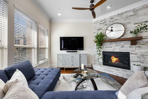 a living room with furniture a fireplace and a flat screen tv