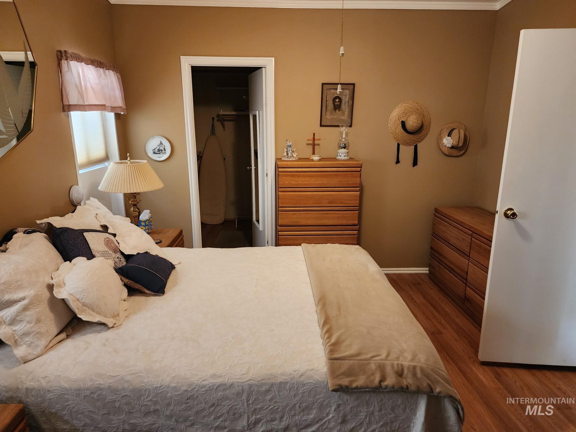 235 5th Street Grand View, ID 83624 - Photo 14 of 22 Room featuring wood-finish flooring, a neutral wall color, and white crown molding