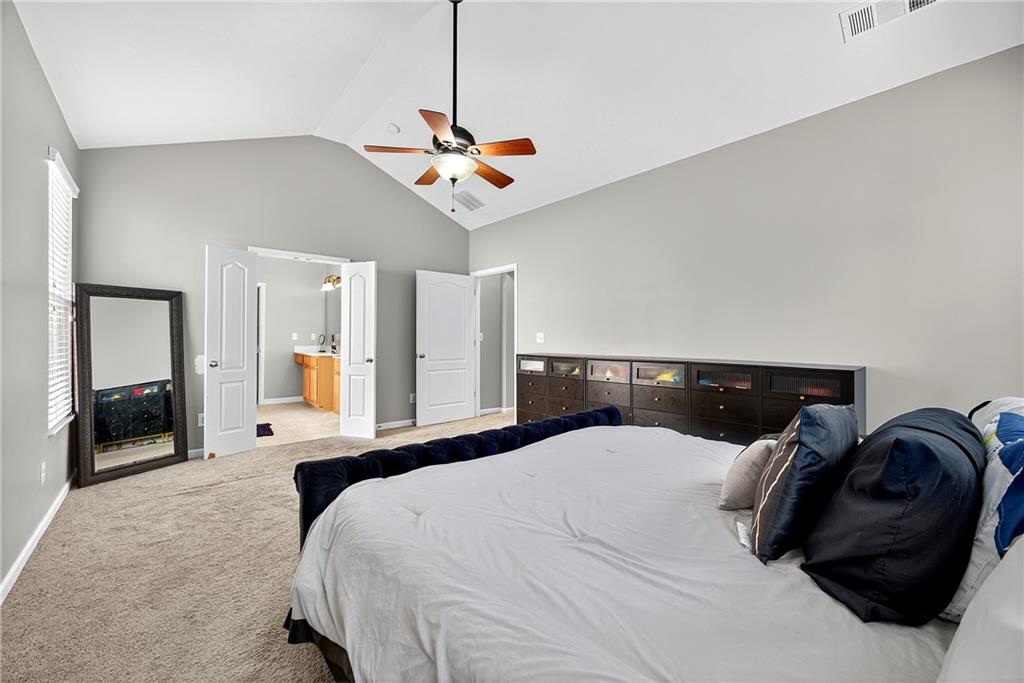 4249 Rosehall Court Atlanta, GA 30349 - Photo 15 of 28 a bedroom with a bed ceiling fan and a wooden floor