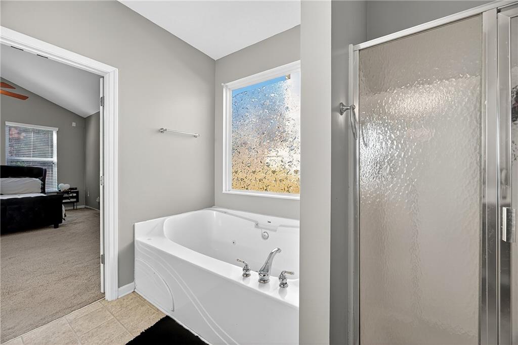 4249 Rosehall Court Atlanta, GA 30349 - Photo 17 of 28 a bathroom with a bathtub and a shower