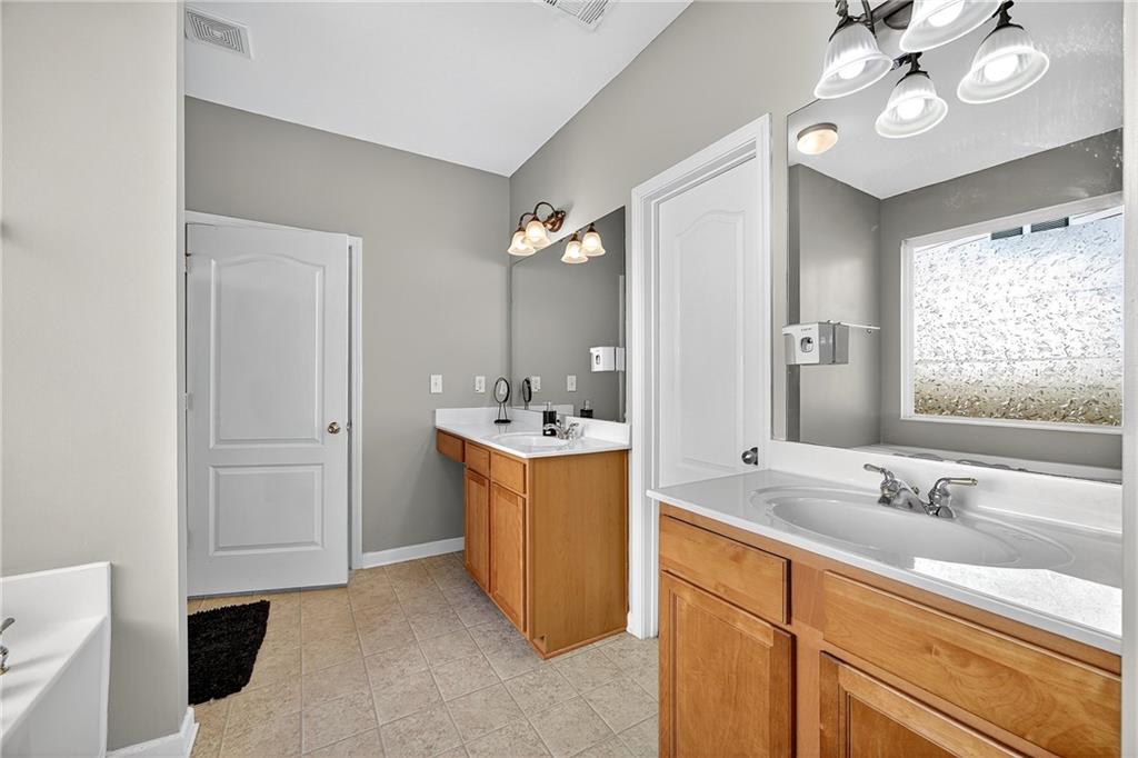 4249 Rosehall Court Atlanta, GA 30349 - Photo 18 of 28 a bathroom with a sink double vanity and a mirror