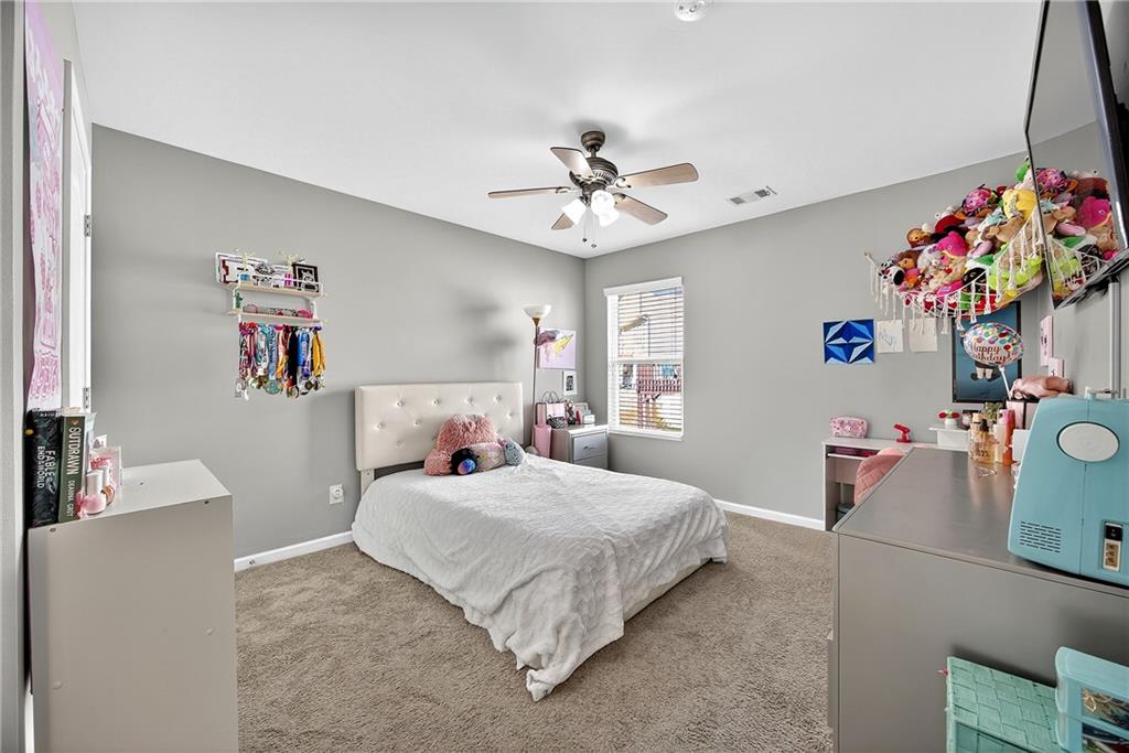 4249 Rosehall Court Atlanta, GA 30349 - Photo 23 of 28 a bedroom with a bed and a chandelier