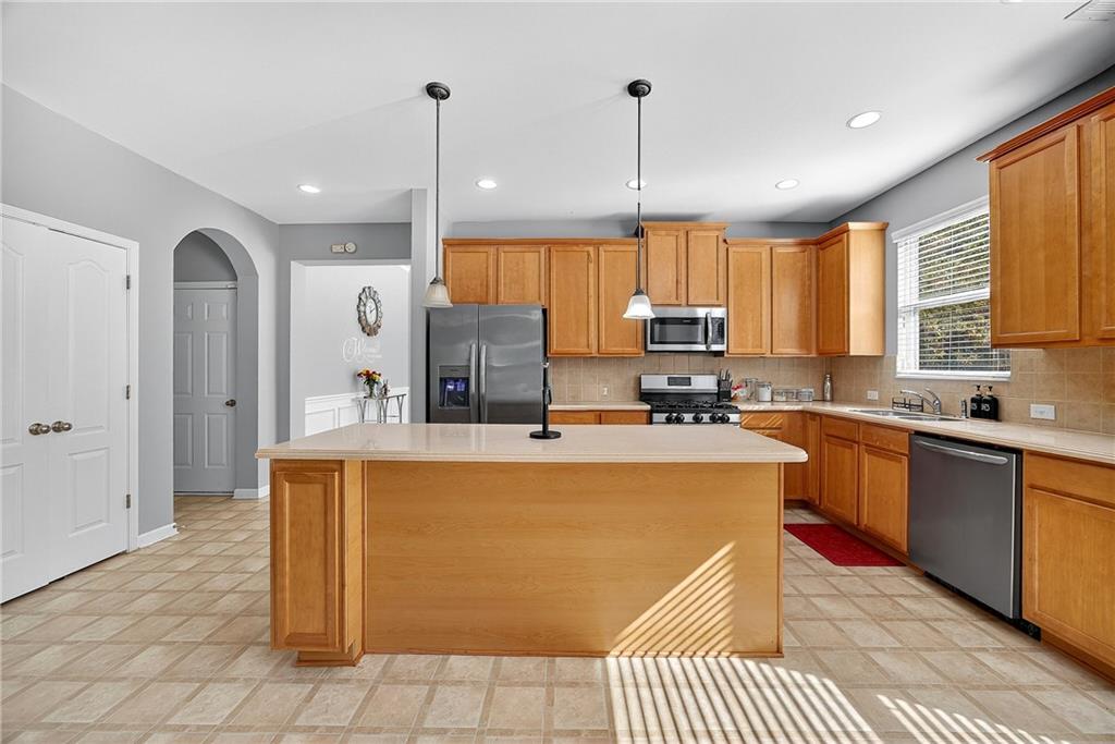 4249 Rosehall Court Atlanta, GA 30349 - Photo 10 of 28 a kitchen with stainless steel appliances granite countertop a refrigerator a sink dishwasher a stove and white cabinets with wooden floor