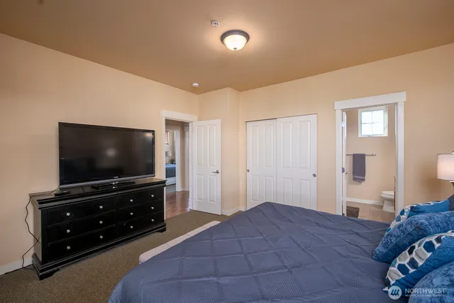 a bedroom with a bed and a flat screen tv