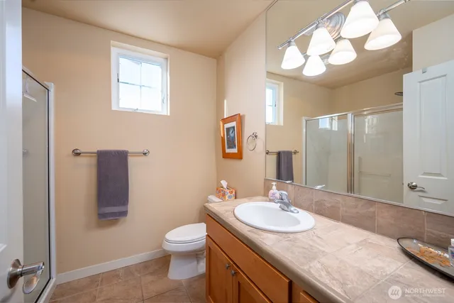 a bathroom with a granite countertop sink a toilet and a mirror