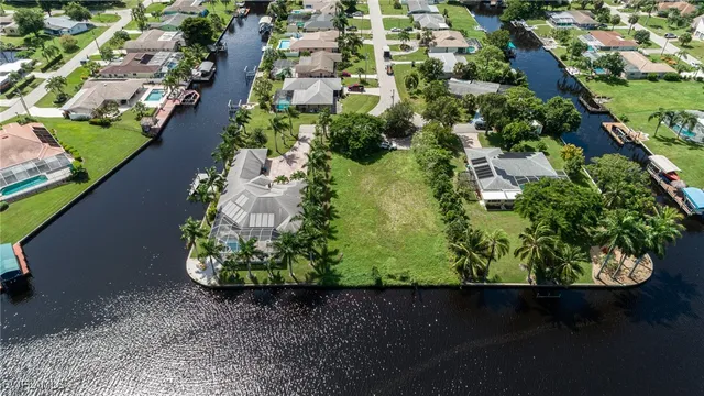 an aerial view of a residential houses with outdoor space and trees all around