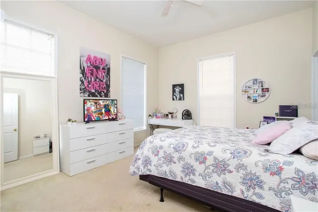 a bedroom with a bed and paintings on the wall