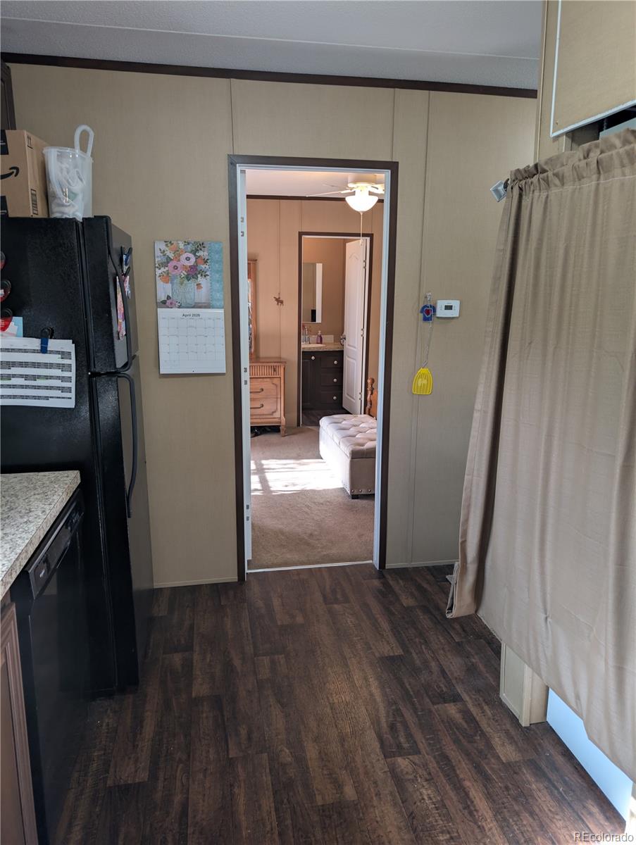 19 Danny Street Castle Rock, CO 80109 - Photo 12 of 33 a view of a hallway to a livingroom with wooden floor and furniture
