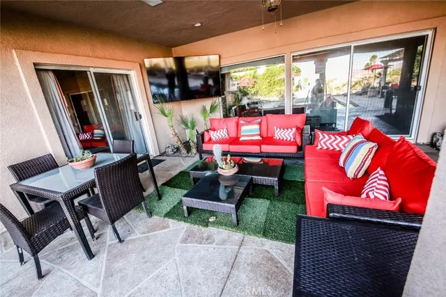 a outdoor space with the couches and dining table with the garden view