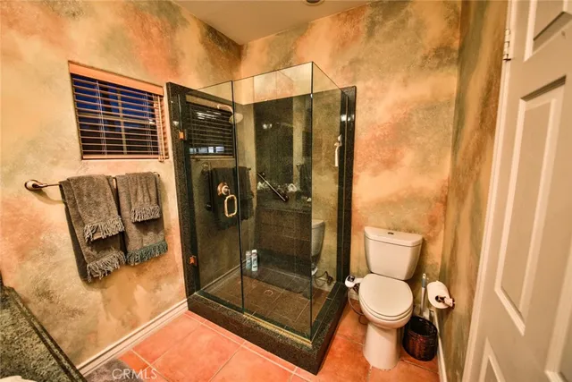 a bathroom with a toilet and a shower