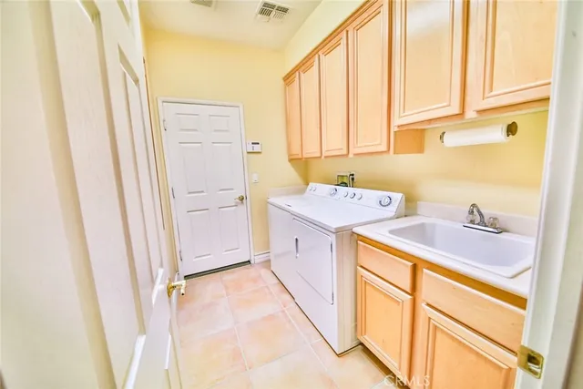 a utility room with a sink a washer and dryer next to a window