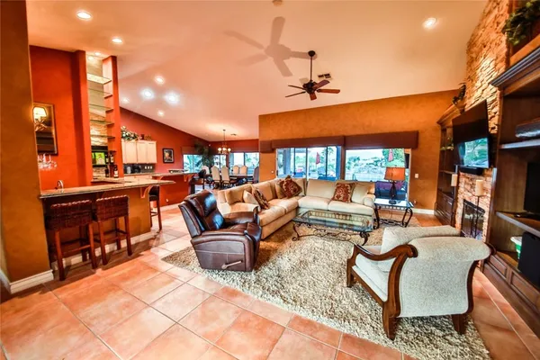 a living room with furniture a ceiling fan and a rug