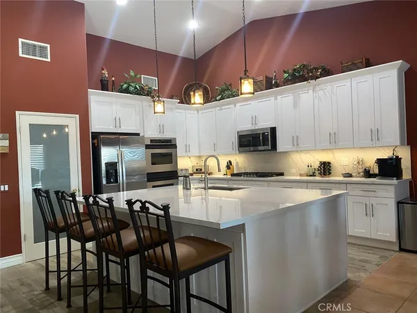 a kitchen with a table chairs microwave and cabinets