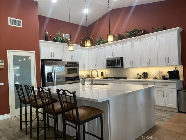 a kitchen with a table chairs microwave and cabinets