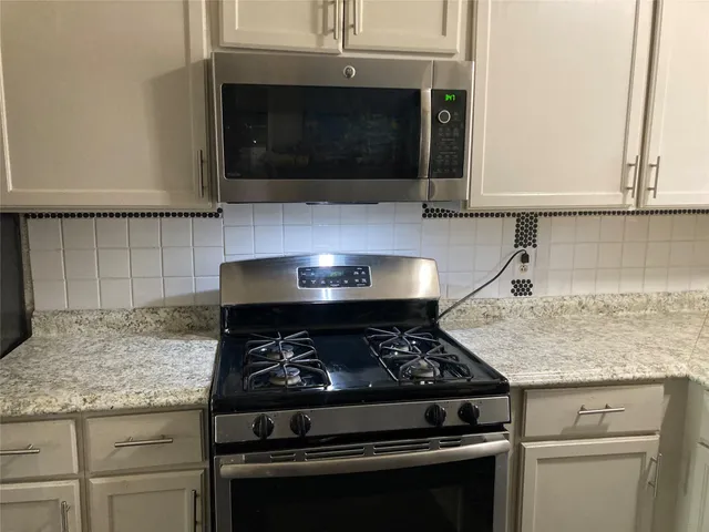 a stove top oven sitting inside of a kitchen