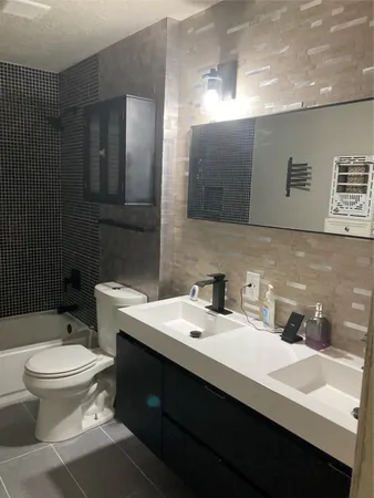 a bathroom with a sink toilet and mirror