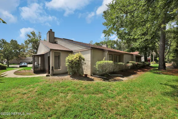 a front view of a house with yard and green space