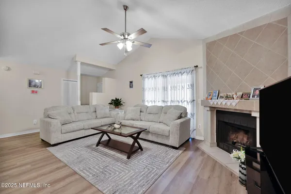 a living room with furniture a fireplace and a flat screen tv