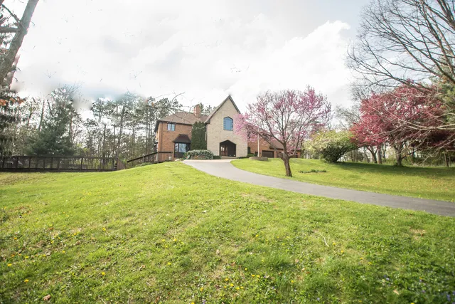a view of a house with a big yard and potted plants