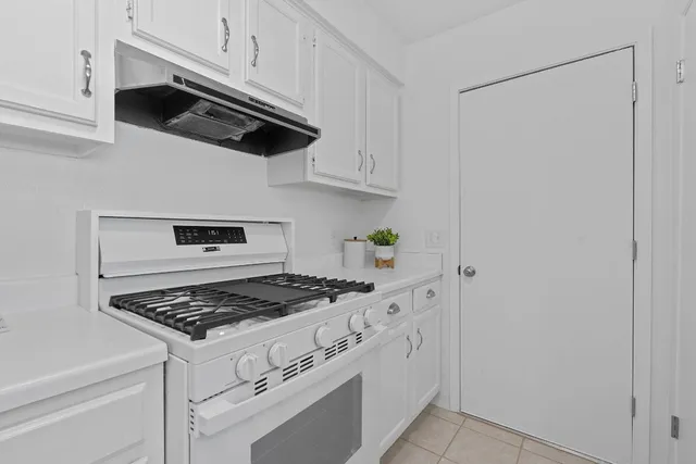 a kitchen with white cabinets and appliances