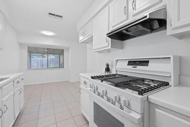 a white stove top oven sitting inside of a kitchen