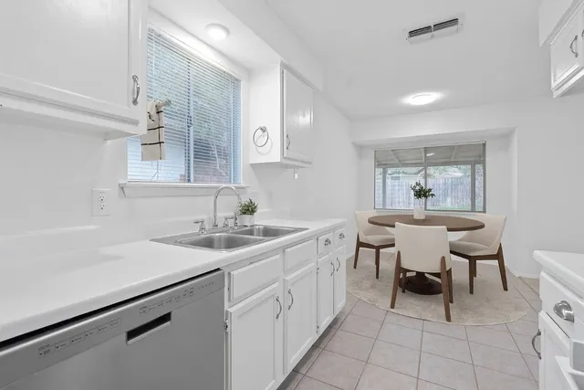 a kitchen with a sink and chairs