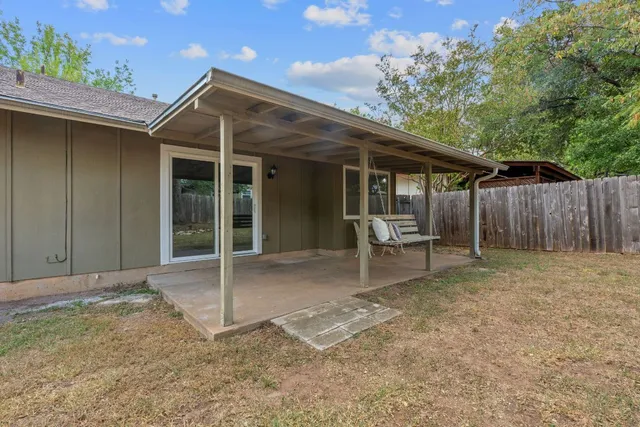 a backyard of a house with table and chairs