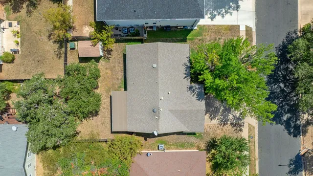 an aerial view of a house with a yard and trees
