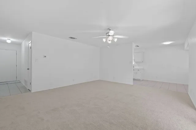 an empty room with chandelier fan