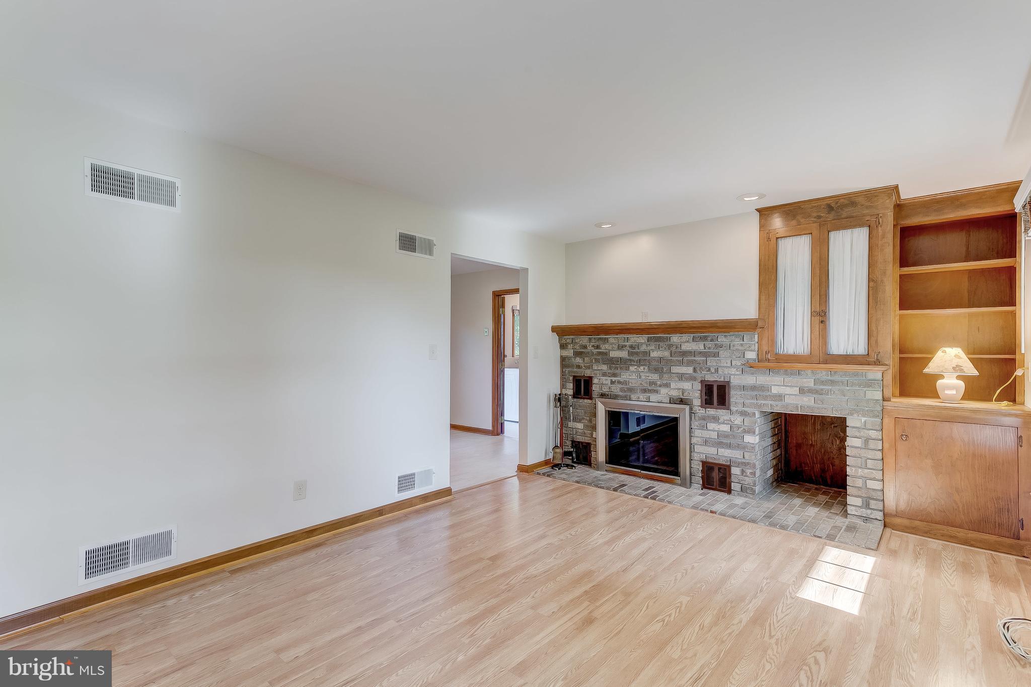 3200 Troyer Road White Hall, MD 21161 - Photo 6 of 36 an empty room with fireplace wooden floor and windows