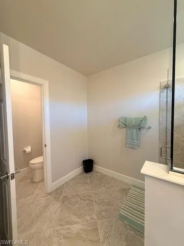 a bathroom with a granite countertop sink a toilet and a mirror