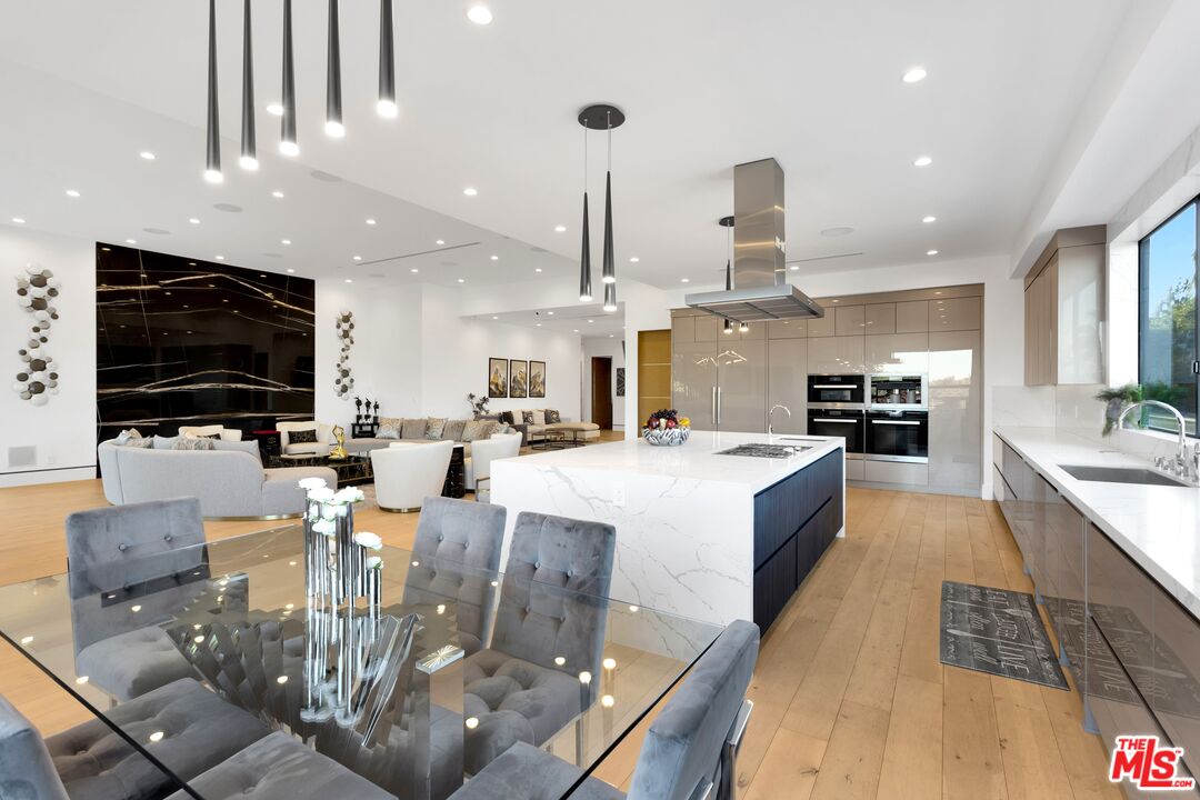 16366 Sloan Drive Los Angeles, CA 90049 - Photo 13 of 54 a large kitchen with stainless steel appliances kitchen island granite countertop a large island in the center