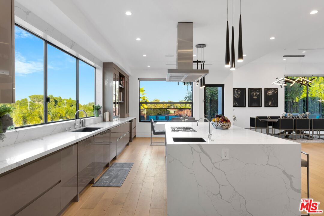 16366 Sloan Drive Los Angeles, CA 90049 - Photo 18 of 54 a large white kitchen with a large window and sitting area