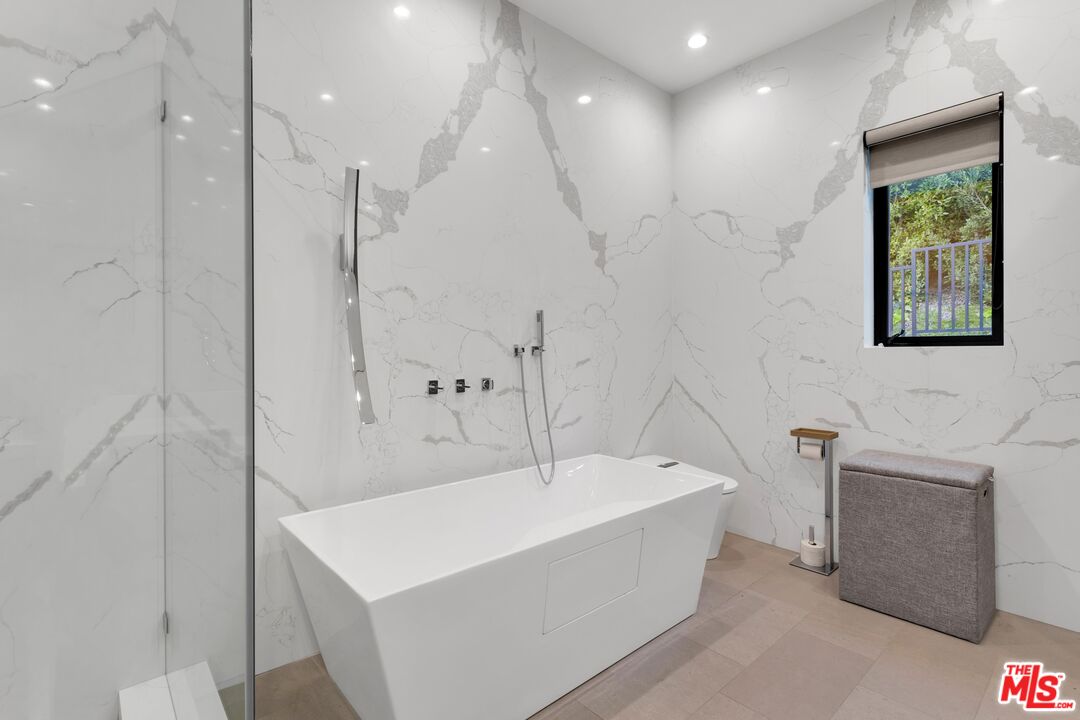 16366 Sloan Drive Los Angeles, CA 90049 - Photo 34 of 54 a bathroom with a bathtub a sink a window and shower