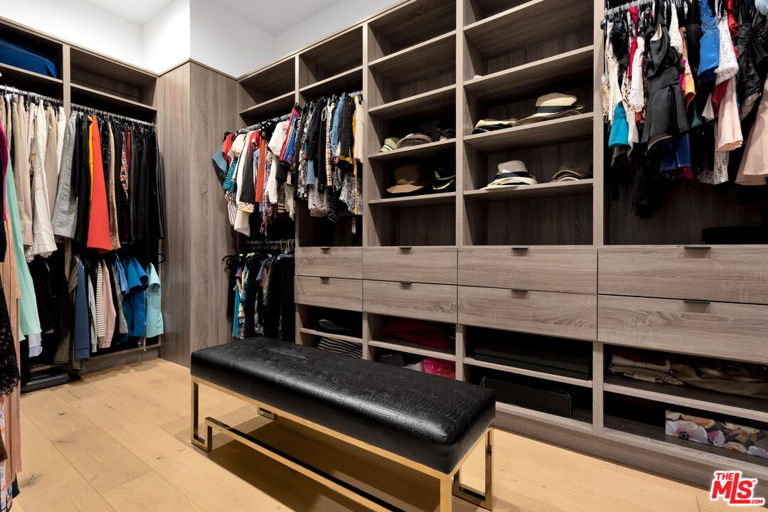 16366 Sloan Drive Los Angeles, CA 90049 - Photo 36 of 54 a view of walk in closet with clothes and shoes