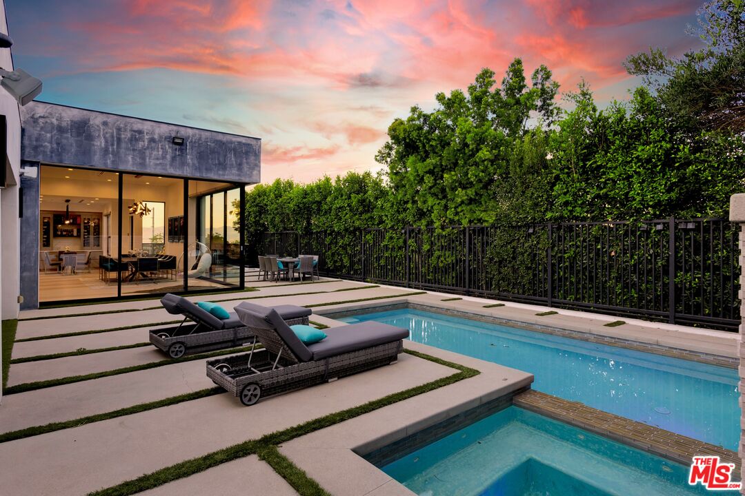 16366 Sloan Drive Los Angeles, CA 90049 - Photo 39 of 54 a view of a swimming pool with chairs in front of a house