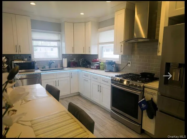 a kitchen with stainless steel appliances granite countertop a sink a stove and a refrigerator