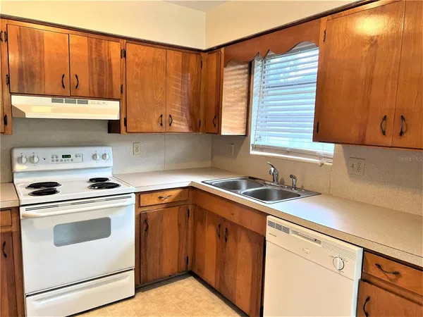 a kitchen with a sink a stove and cabinets