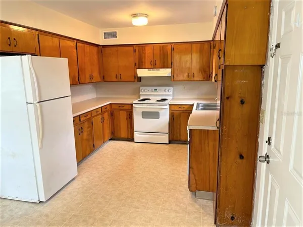 a kitchen with a refrigerator sink stove and cabinets