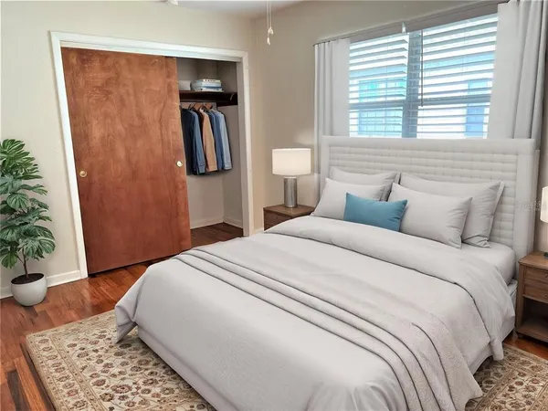 a bedroom with a large bed and potted plant