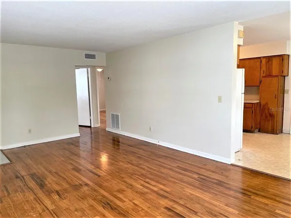 a view of an empty room with wooden floor