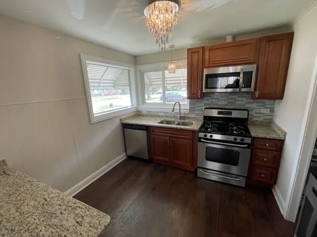 a kitchen with stainless steel appliances granite countertop a sink stove and microwave