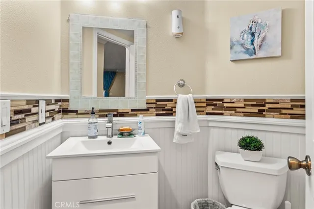 a bathroom with a sink a toilet and a mirror