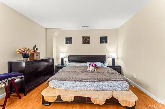 a bedroom with a bed and wooden floor