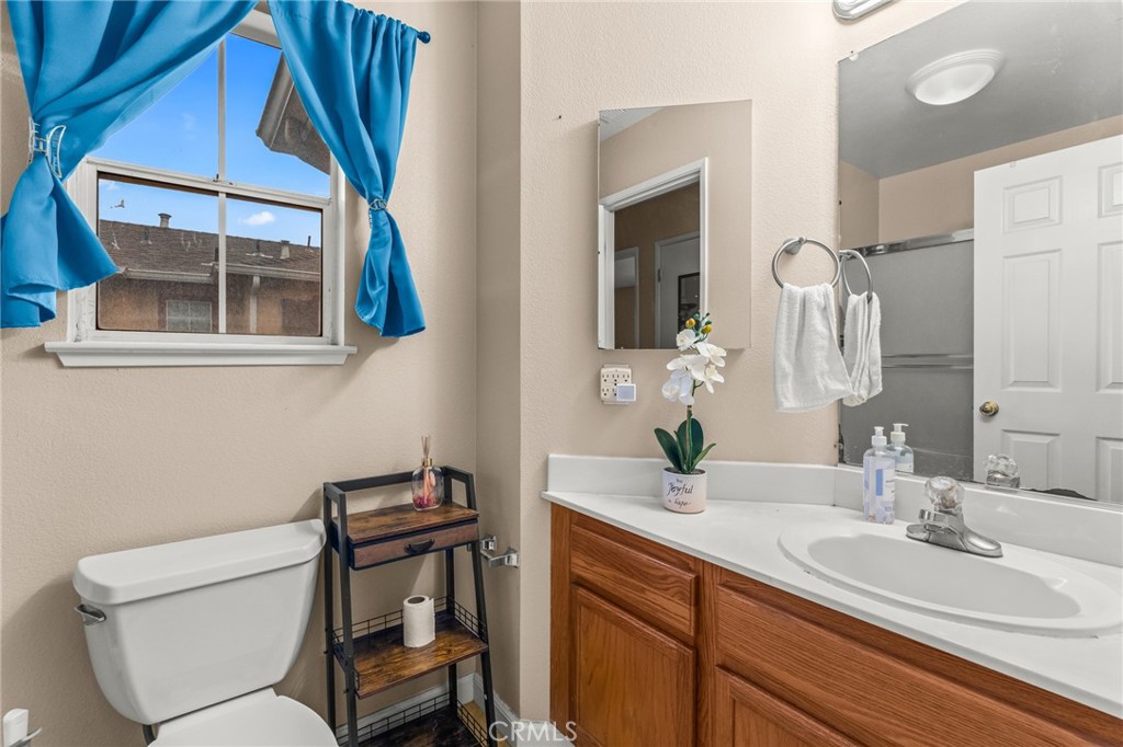 1560 Firestone Loop San Jose, CA 95116 - Photo 23 of 33 a bathroom with a toilet a sink and mirror