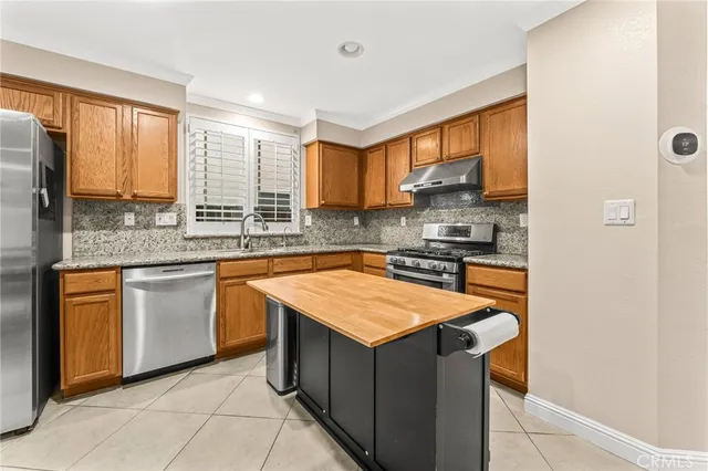 a kitchen with stainless steel appliances granite countertop sink stove and refrigerator