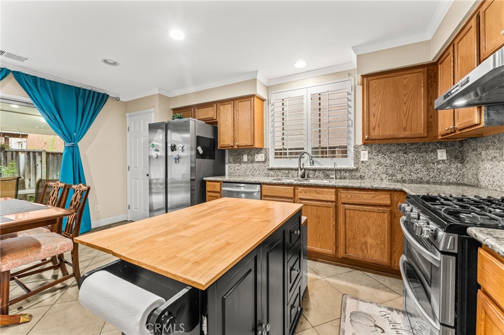 1560 Firestone Loop San Jose, CA 95116 - Photo 10 of 33 a kitchen with stainless steel appliances granite countertop a sink a stove a refrigerator cabinets and a dining table