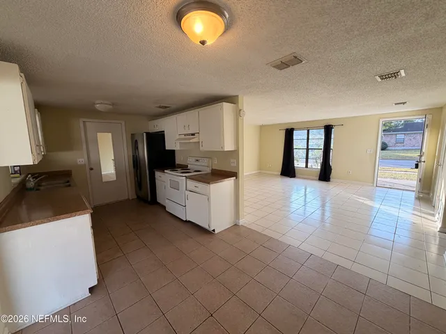 a kitchen with stainless steel appliances a refrigerator sink and cabinets