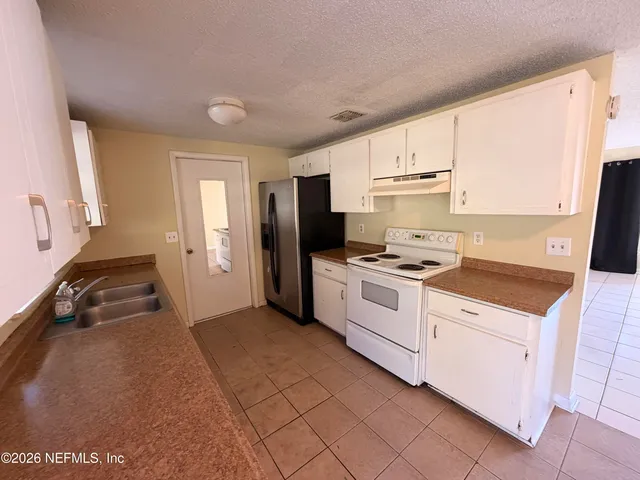 a kitchen with a stove a sink and a refrigerator